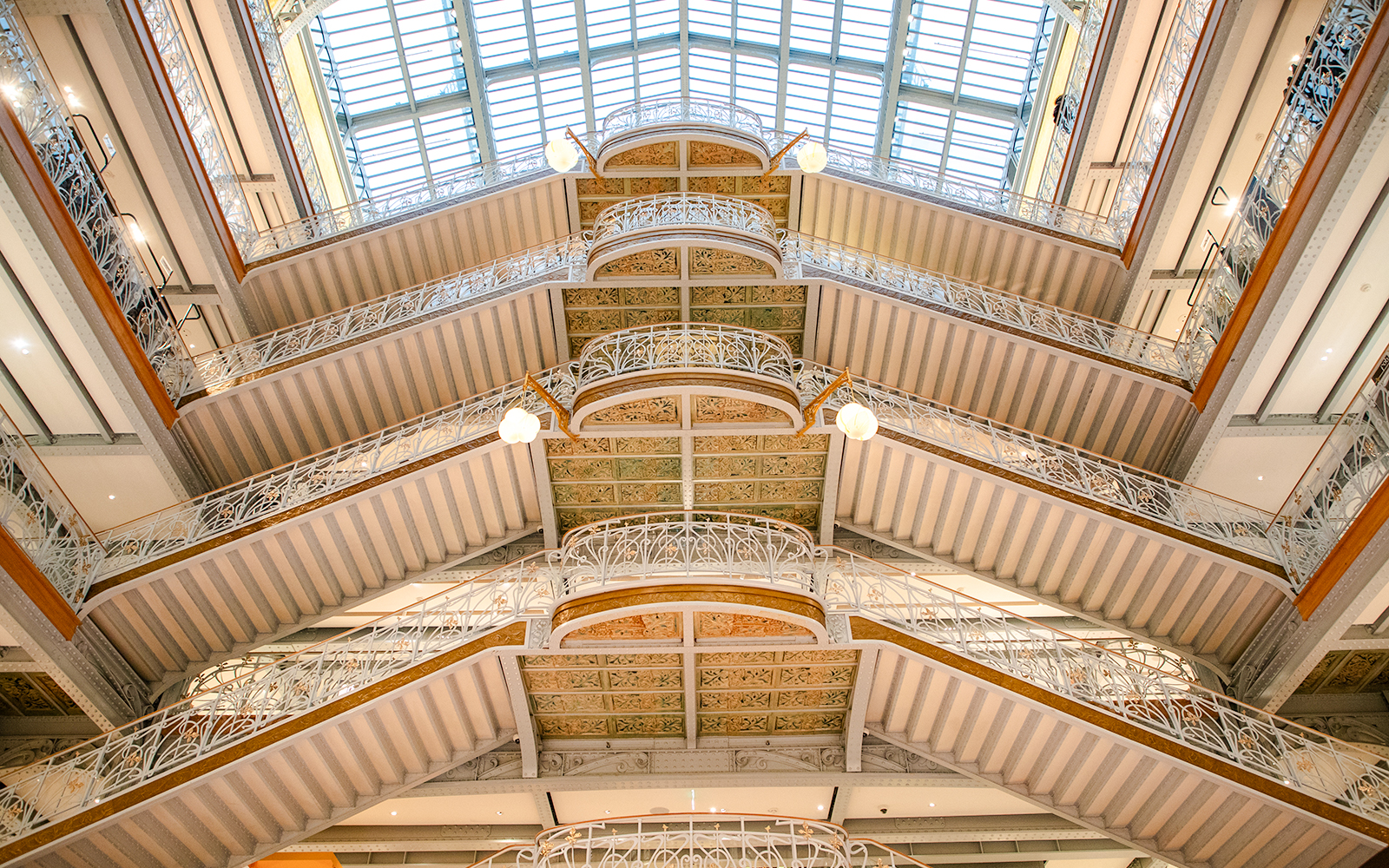 Samaritaine Paris interior with ornate balconies and glass ceiling.