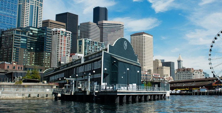 Seattle Aquarium on Pier 59 with city skyline and Ferris wheel in background.
