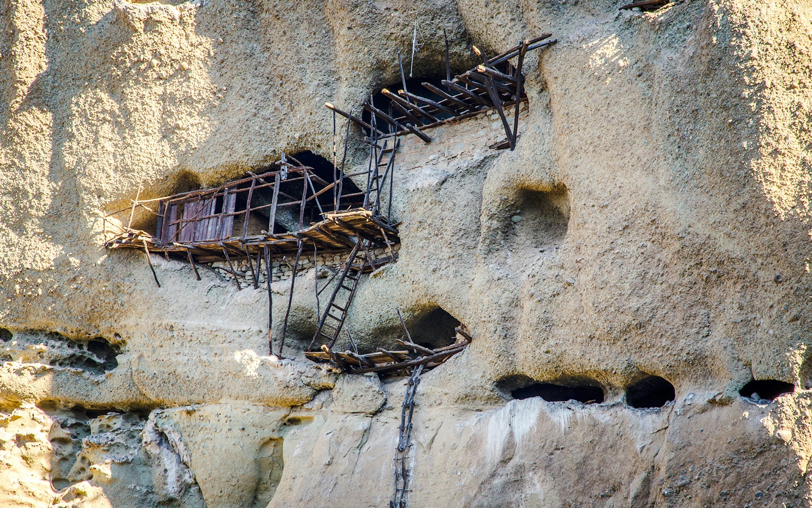 Extreme hermitages in rock face above St Antony's hermitage, Meteora, Greece.