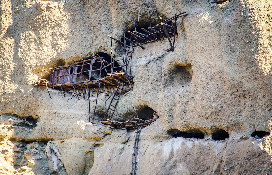 Extreme hermitages in rock face above St Antony's hermitage, Meteora, Greece.