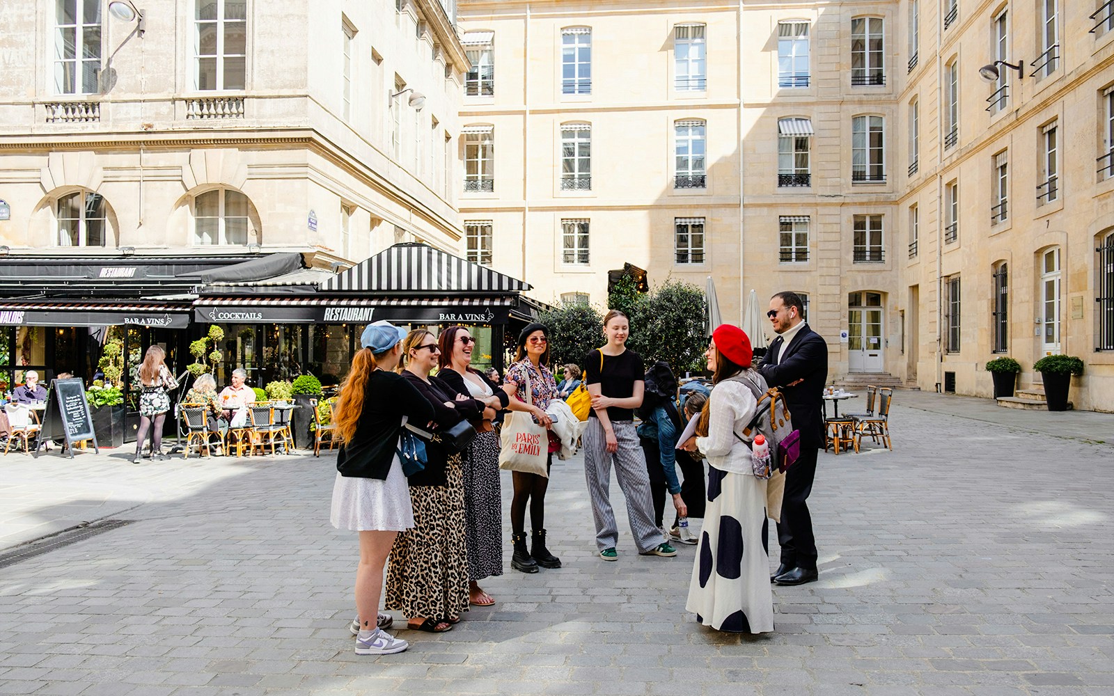 Tour guide with tourists on Emily in Paris Locations Walking Tour in Paris courtyard.