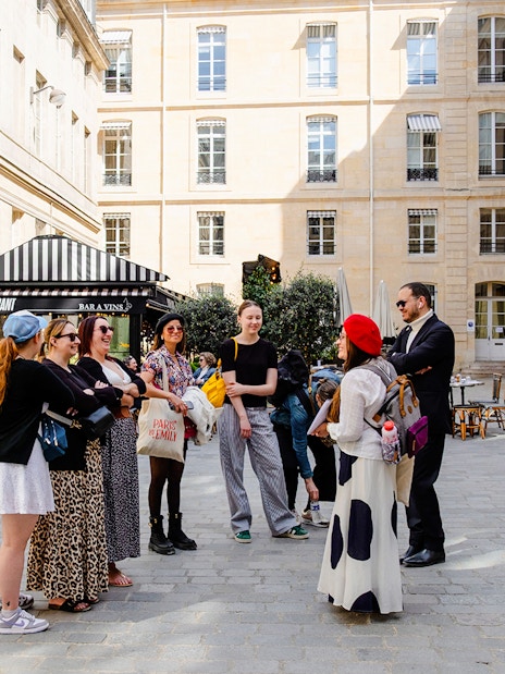 Tour guide with tourists on Emily in Paris Locations Walking Tour in Paris courtyard.