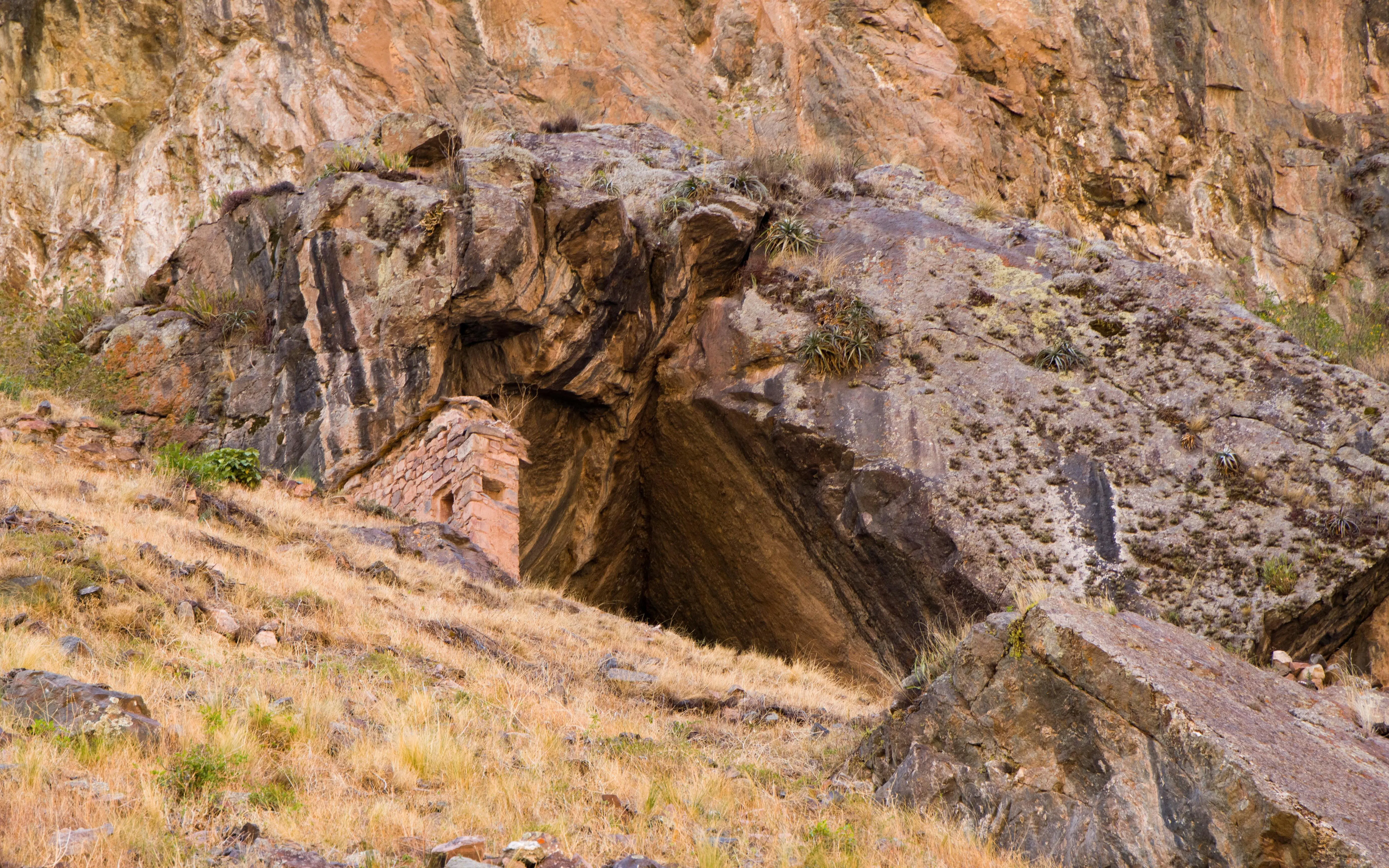 Ñaupay Iglesia cave entrance in rocky hillside, Andes Mountains, Cusco, Peru.