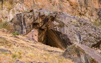 Ñaupay Iglesia cave entrance in rocky hillside, Andes Mountains, Cusco, Peru.