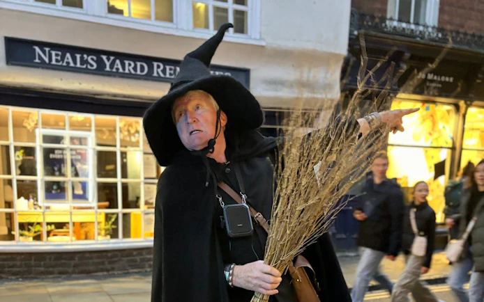 Guide in witch costume leading York Old Town walking tour.