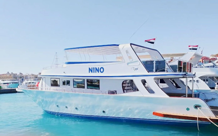 Tour boat in Hurghada harbor for sunset dive, dolphin watching, snorkeling, and lunch.