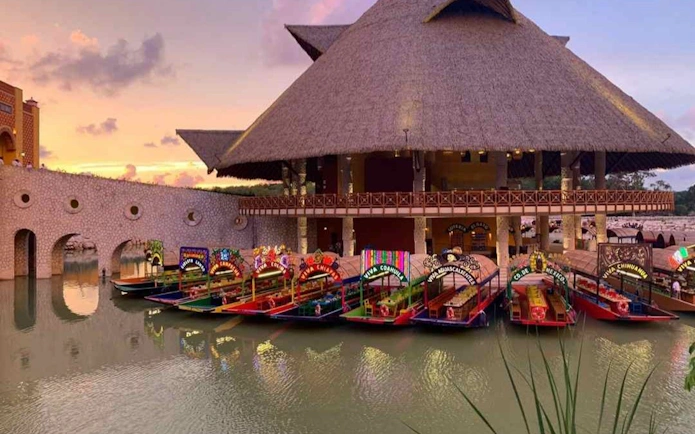 Colorful trajineras docked at Xoximilco Park, Mexico, during sunset.
