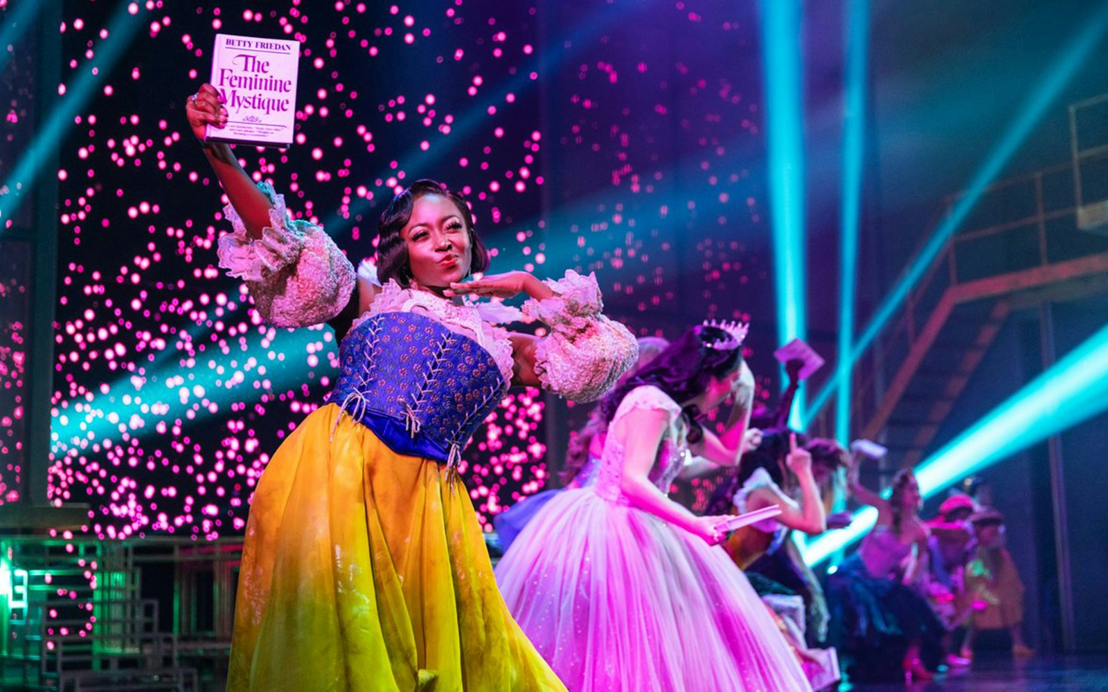 Performer on stage holding a book during "Once Upon a One More Time" show.