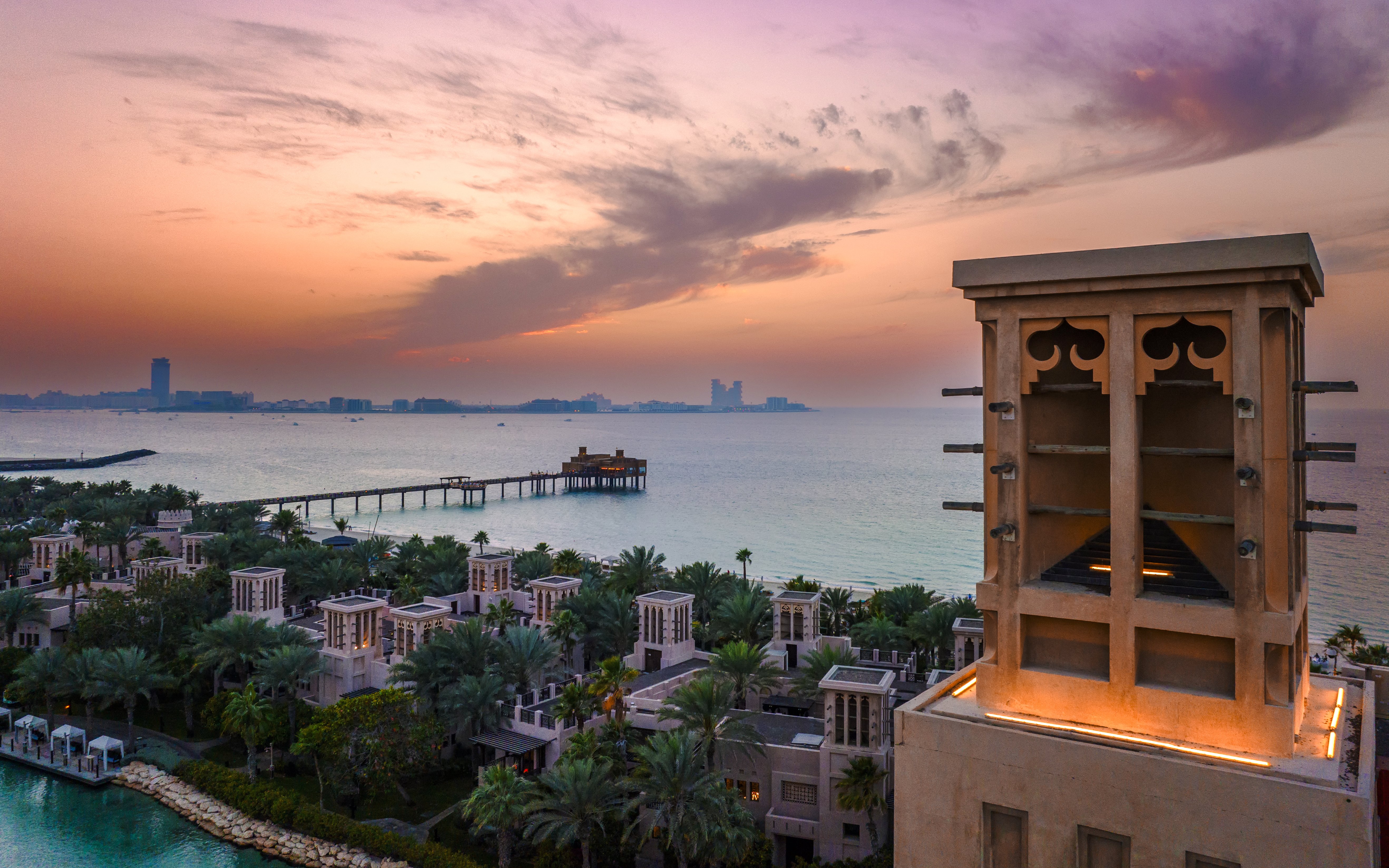 Madinat Jumeirah at sunset with traditional architecture and ocean view in Dubai.
