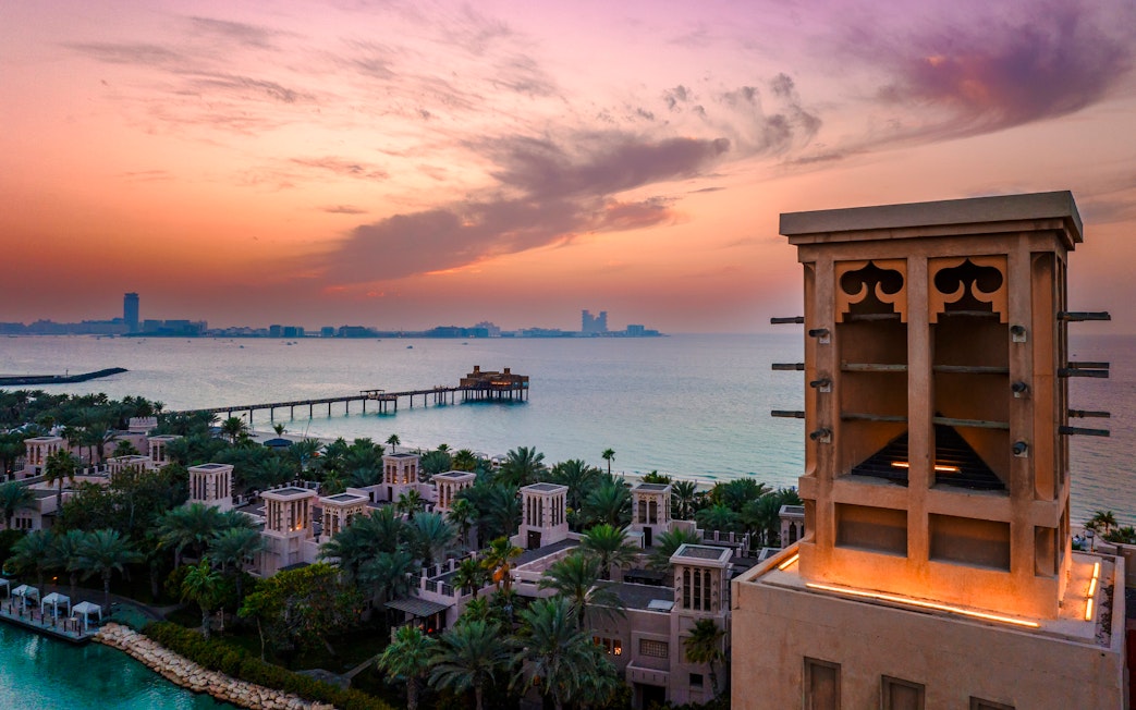 Madinat Jumeirah at sunset with traditional architecture and ocean view in Dubai.
