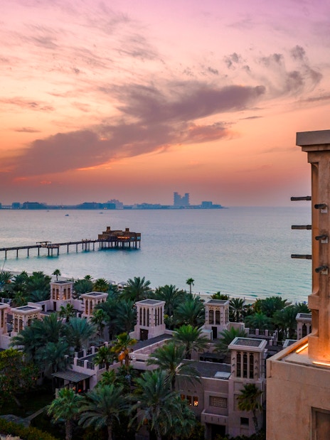 Madinat Jumeirah at sunset with traditional architecture and ocean view in Dubai.