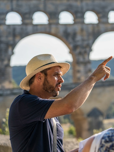 Tour guide explaining Pont du Gard to visitors in Provence.