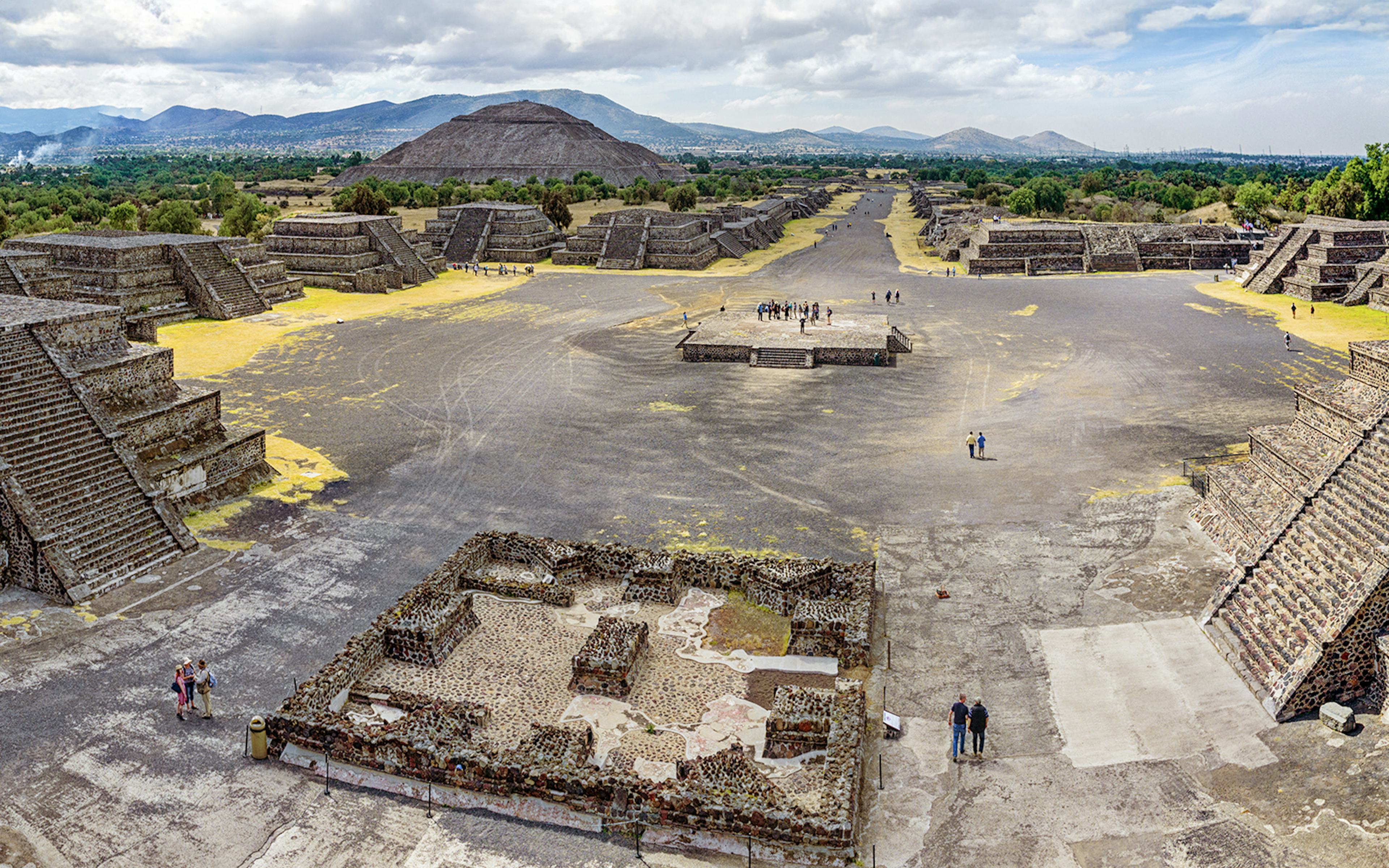 Pyramid of the Sun and Avenue of the Dead in Teotihuacan, Mexico, with tourists exploring the ancient site.