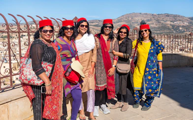 Group of tourists wearing red hats at a viewpoint in Fes Medina, Morocco.