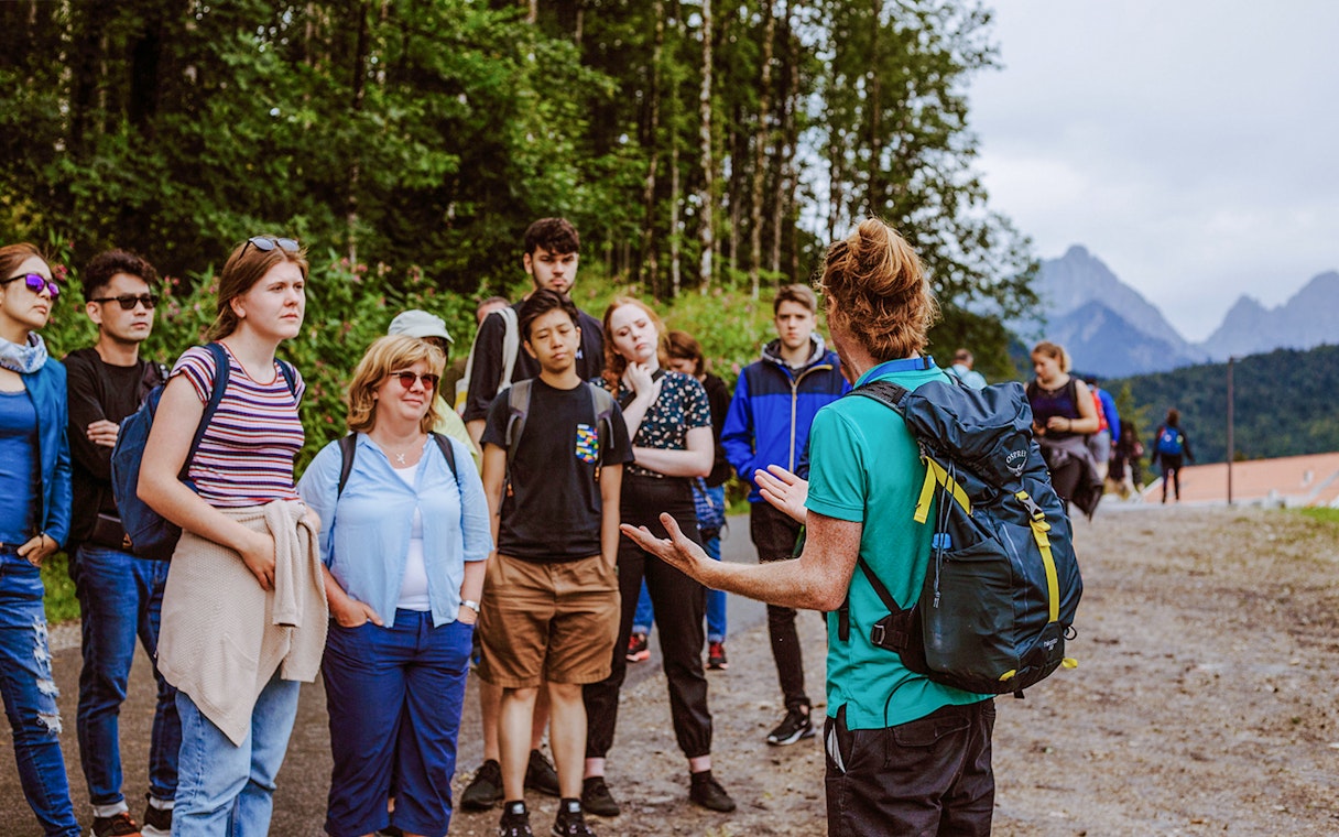 Tour group listening to a guide near Neuschwanstein Castle, Germany.