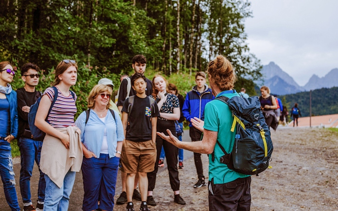 Tour group listening to a guide near Neuschwanstein Castle, Germany.