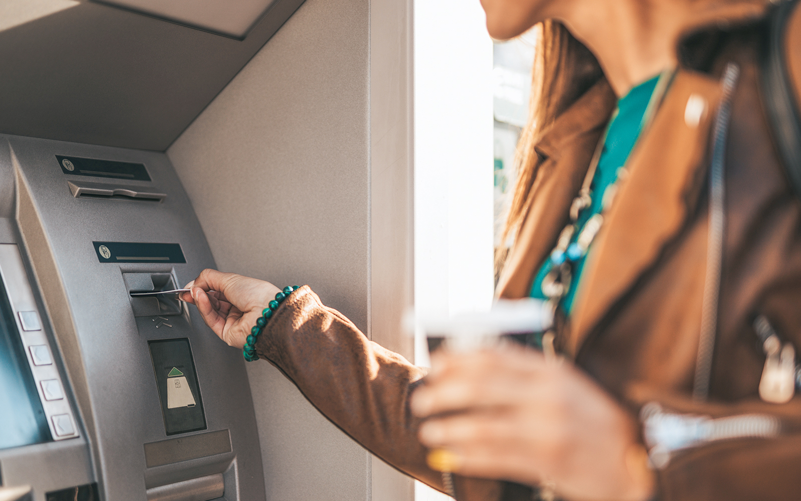 Young woman withdraws money from ATM machine