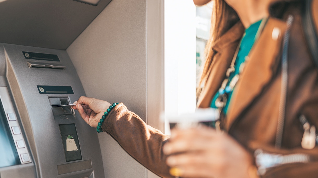 Young woman withdraws money from ATM machine