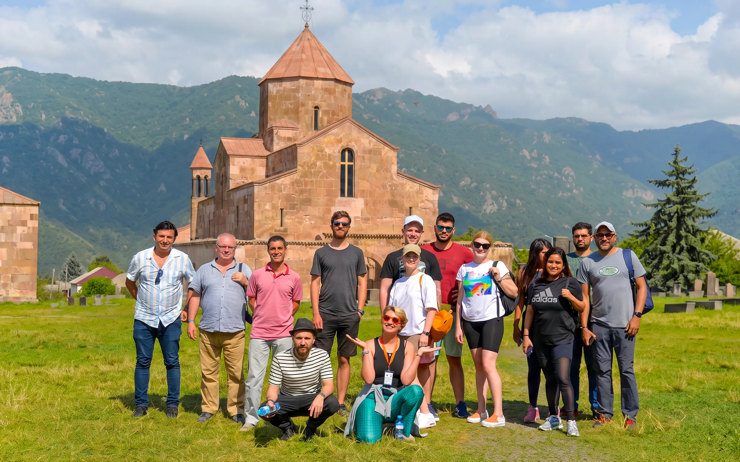 Group of tourists on a guided tour in front of Odzun Church, Armenia.