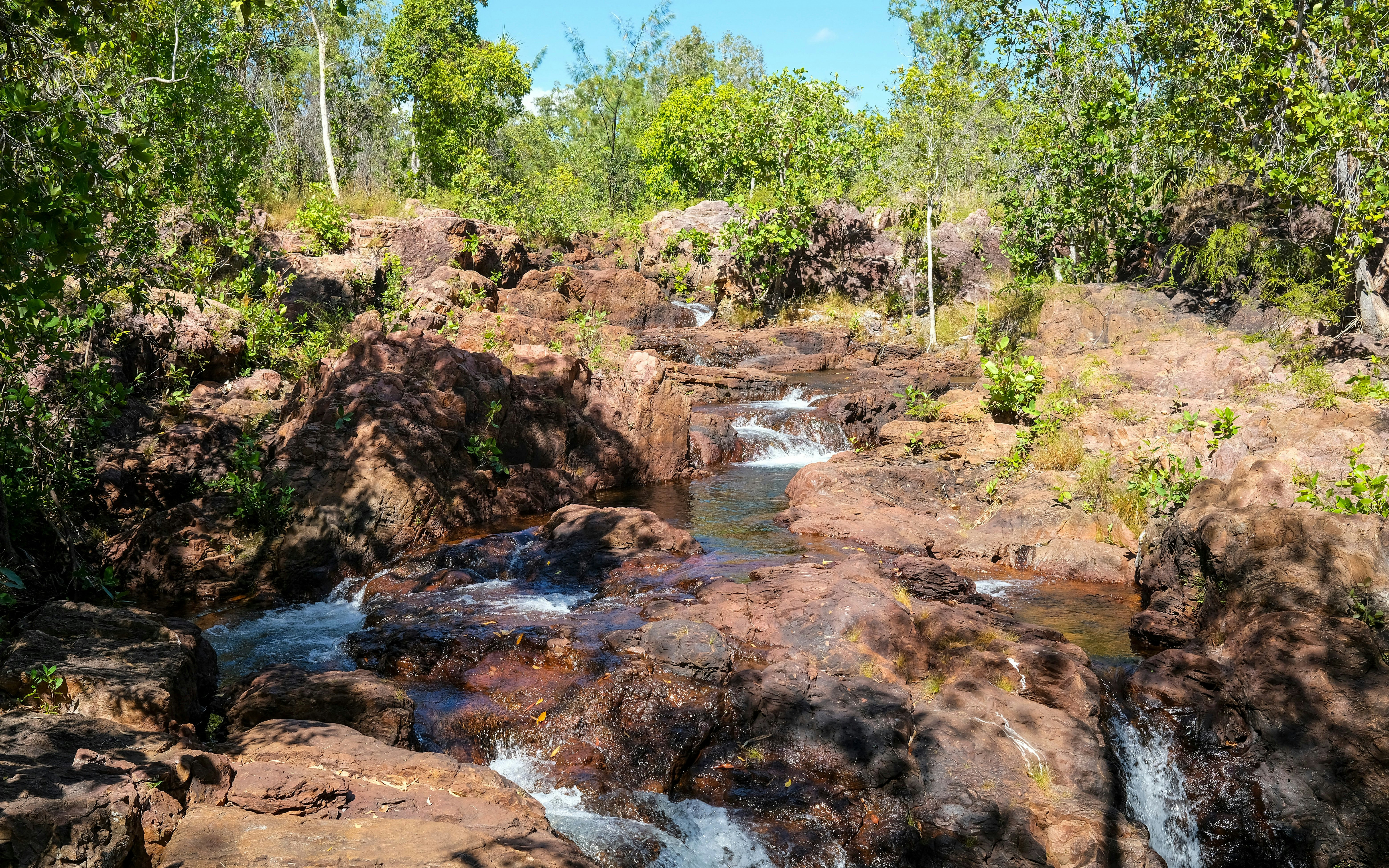 Buley Rockhole cascading water over rocky terrain surrounded by lush greenery in Litchfield National Park.