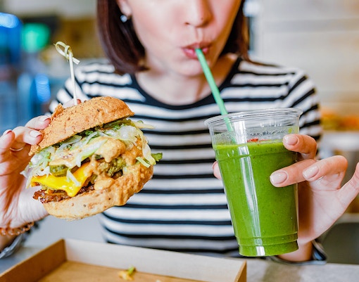 Vegan burger and smoothie served at a cafe table.
