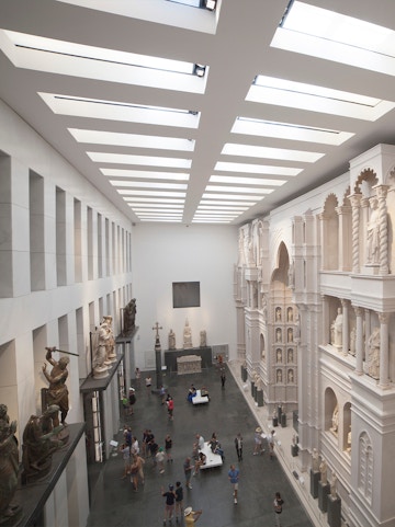 Visitors exploring sculptures and architectural displays inside Museo dell'Opera del Duomo, Florence.