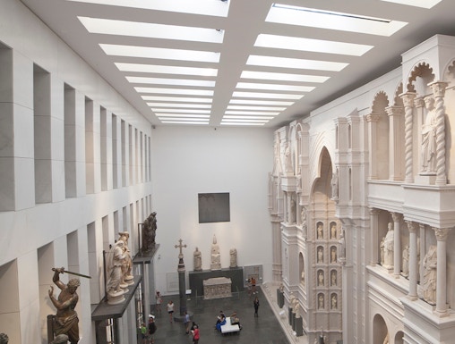 Visitors exploring sculptures and architectural displays inside Museo dell'Opera del Duomo, Florence.