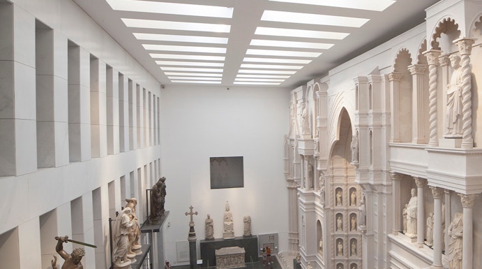 Visitors exploring sculptures and architectural displays inside Museo dell'Opera del Duomo, Florence.