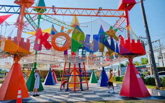 Children playing in a colorful outdoor playground with netting and geometric structures in Phuket.