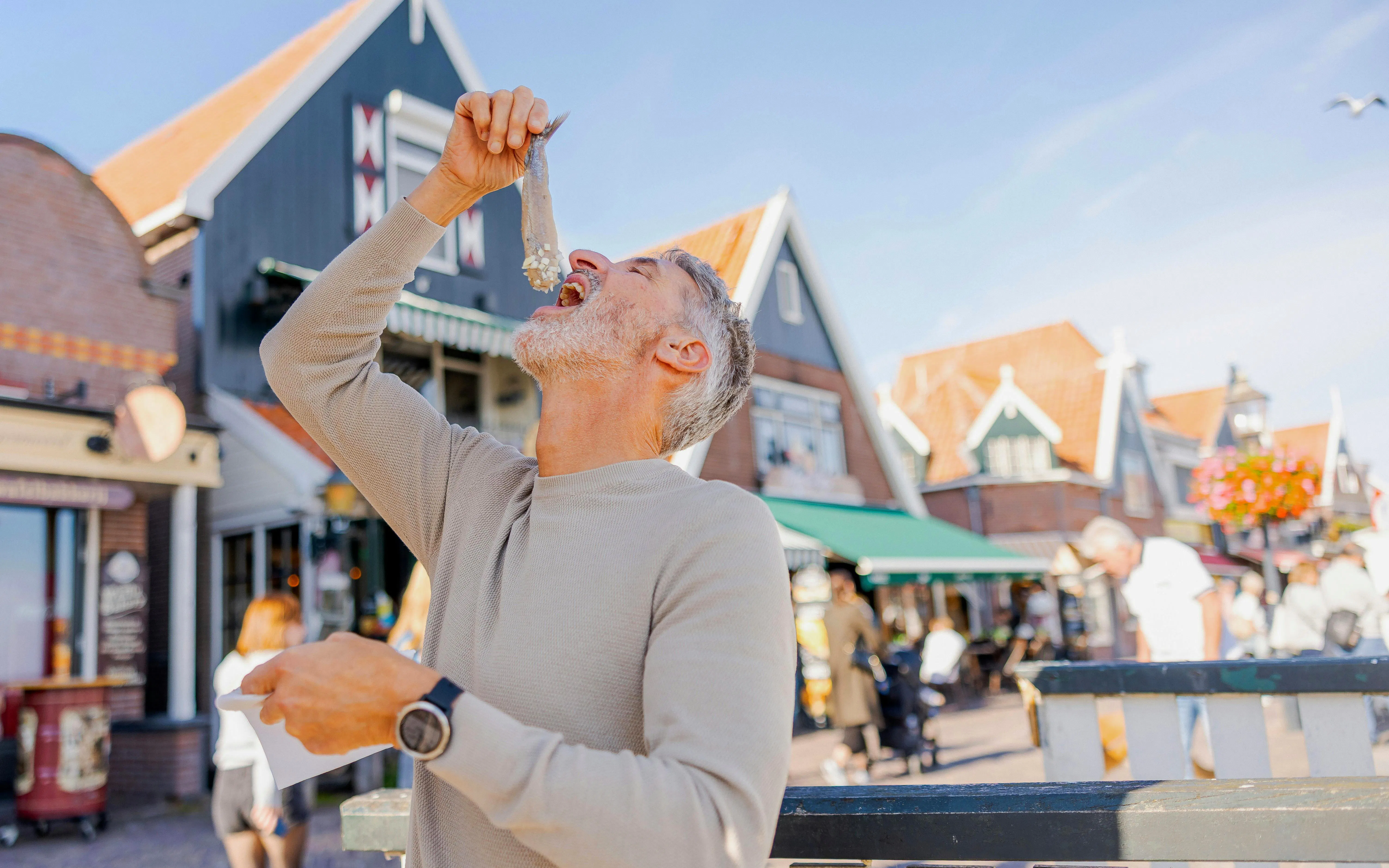 Man eating Dutch soused herring in Volendam street.
