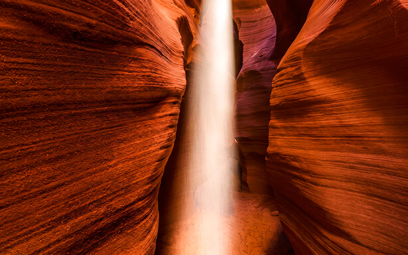 Sunbeam illuminating the narrow sandstone walls of Secret Antelope Canyon.