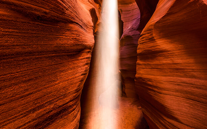 Sunbeam illuminating the narrow sandstone walls of Secret Antelope Canyon.
