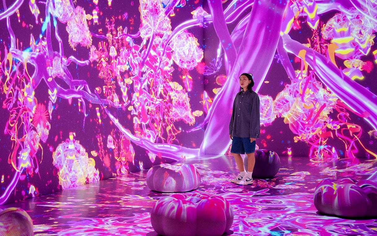 Tourist exploring vibrant digital art installation at House of Hype, Dubai.