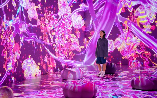 Tourist exploring vibrant digital art installation at House of Hype, Dubai.