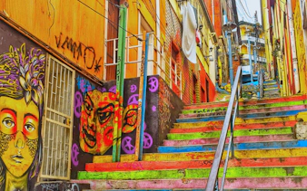 Colorful staircase with vibrant street art murals in Valparaíso, Chile.