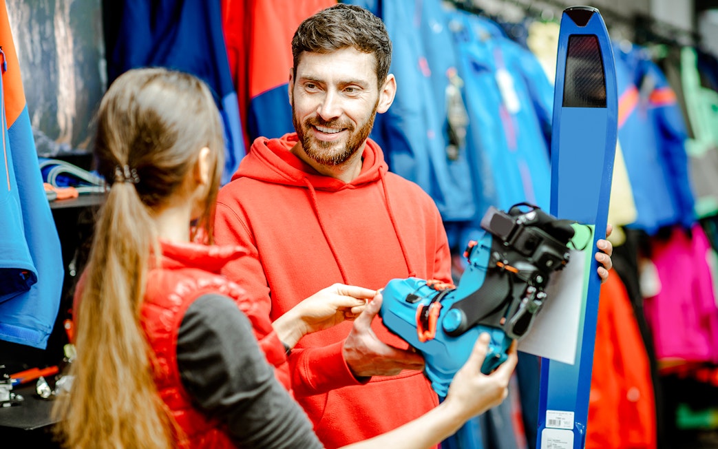 Skiers selecting equipment at an indoor ski park.
