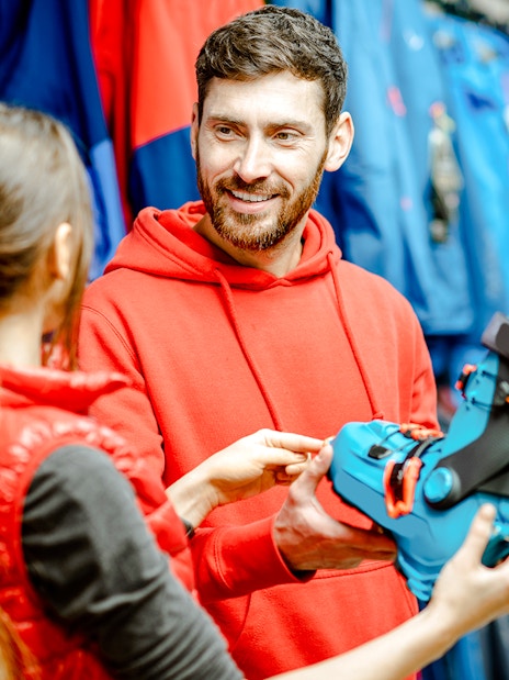 Skiers selecting equipment at an indoor ski park.