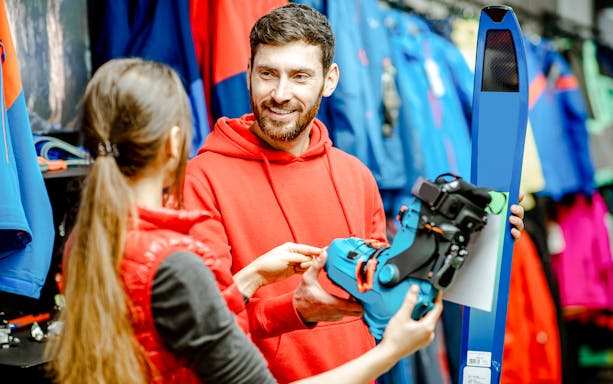 Skiers selecting equipment at an indoor ski park.