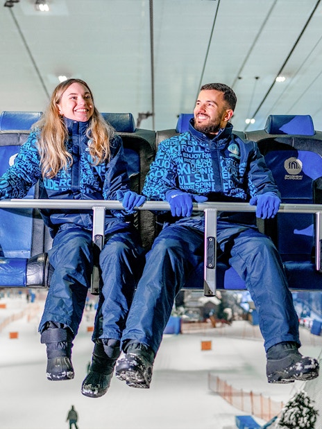Couple on a chairlift at Ski Dubai indoor ski resort.