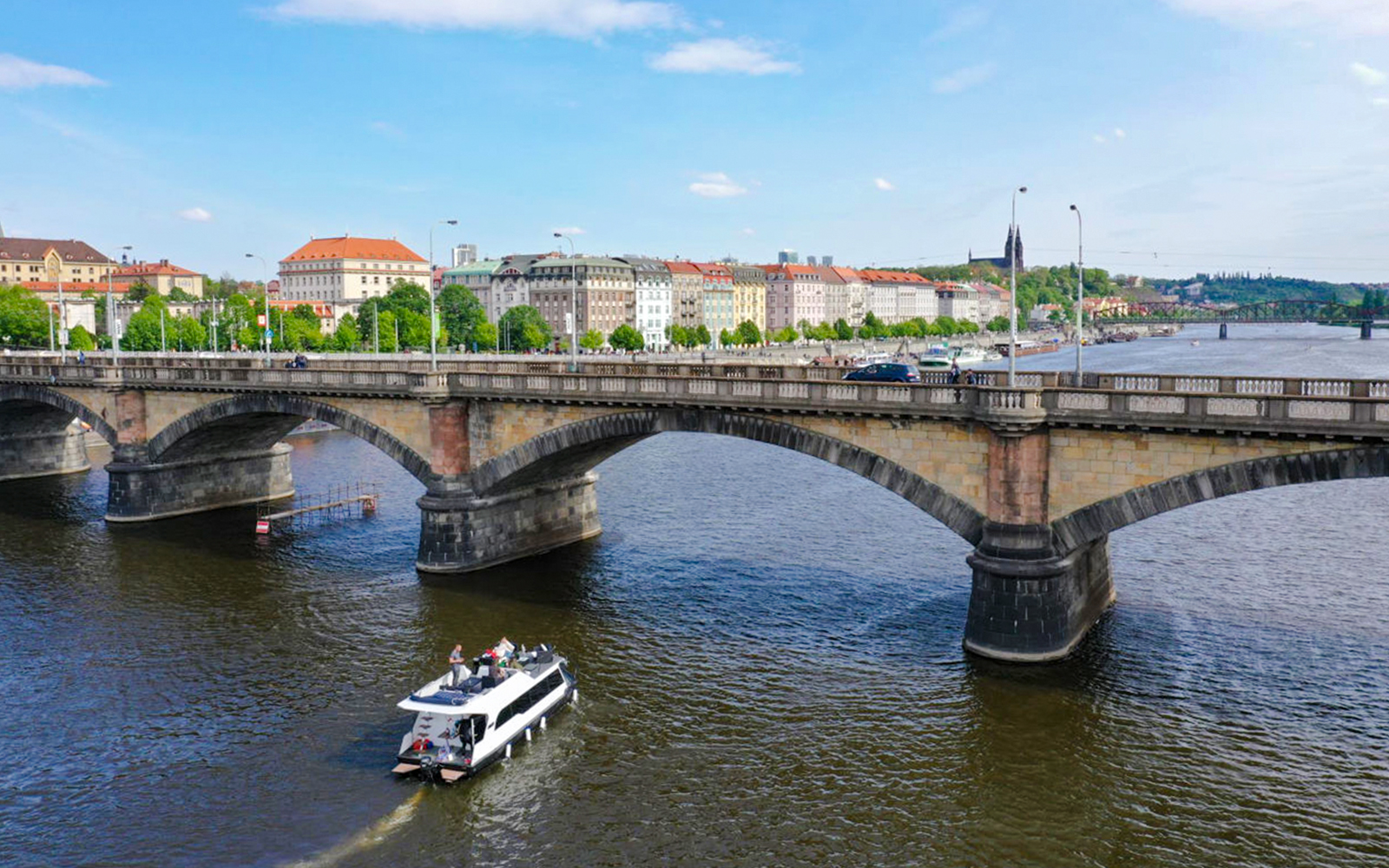 Prague yacht boat cruising near Charles Bridge on the Vltava River.