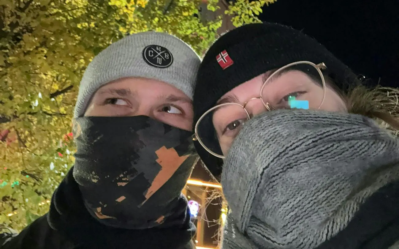 Couple in winter attire exploring Brussels at night during a self-guided murder mystery game.