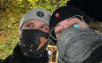 Couple in winter attire exploring Brussels at night during a self-guided murder mystery game.
