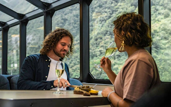 Couple enjoying gourmet canapés and champagne on Milford Sound cruise.