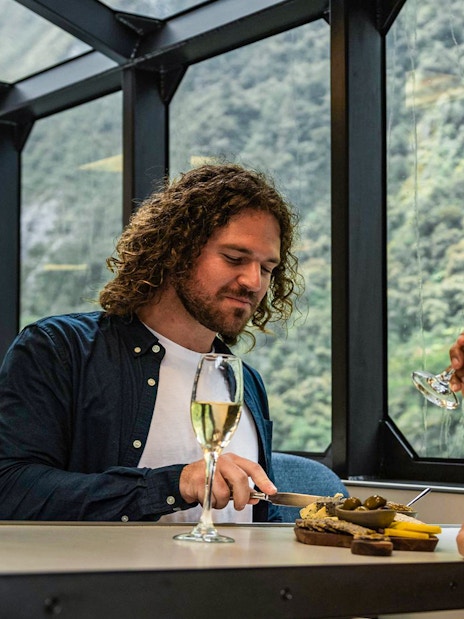 Couple enjoying gourmet canapés and champagne on Milford Sound cruise.