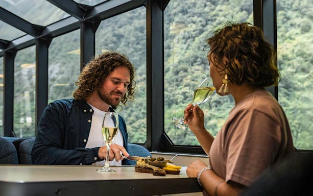 Couple enjoying gourmet canapés and champagne on Milford Sound cruise.