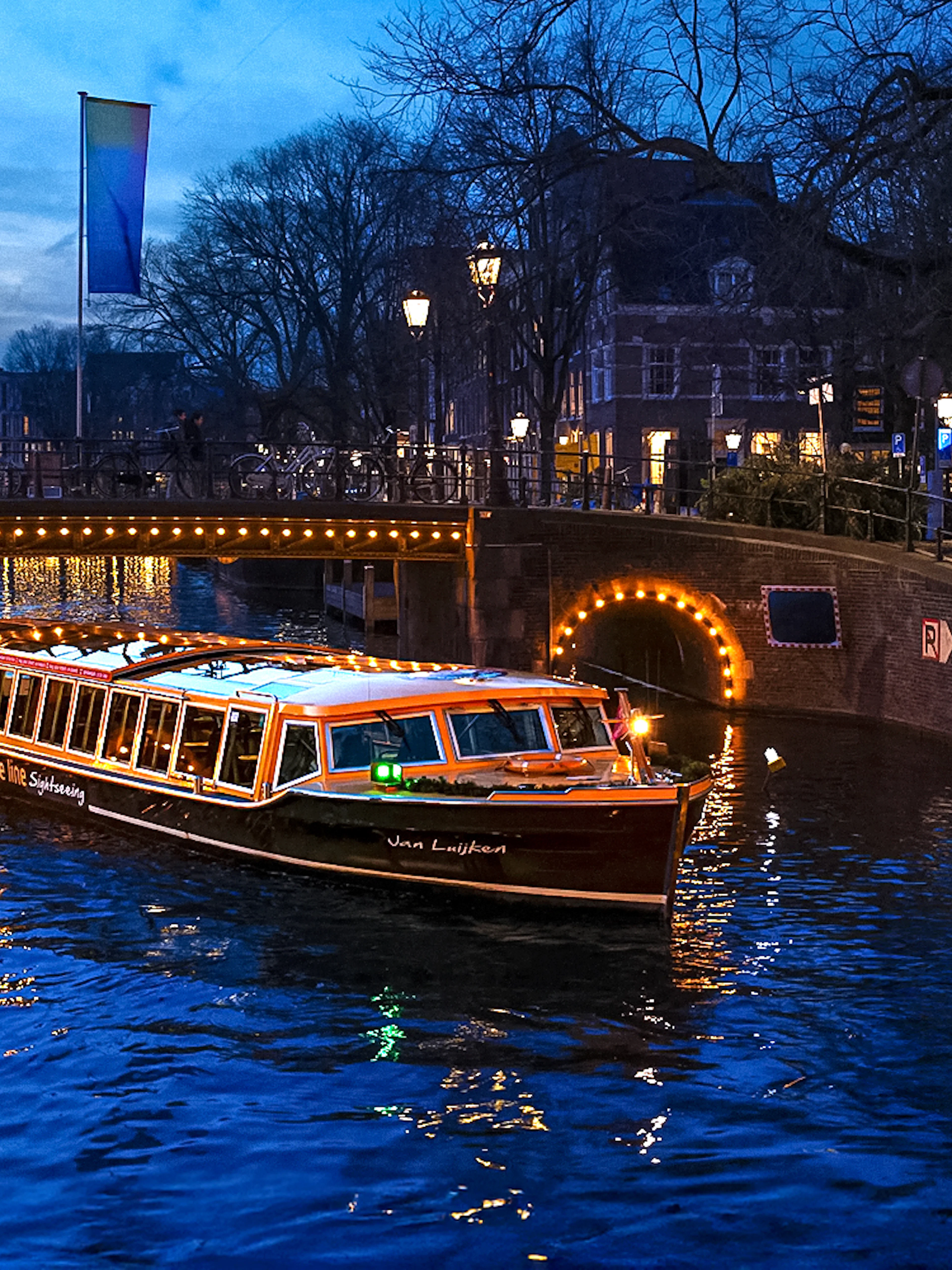 Traditional canal boat cruising during Amsterdam Light Festival.