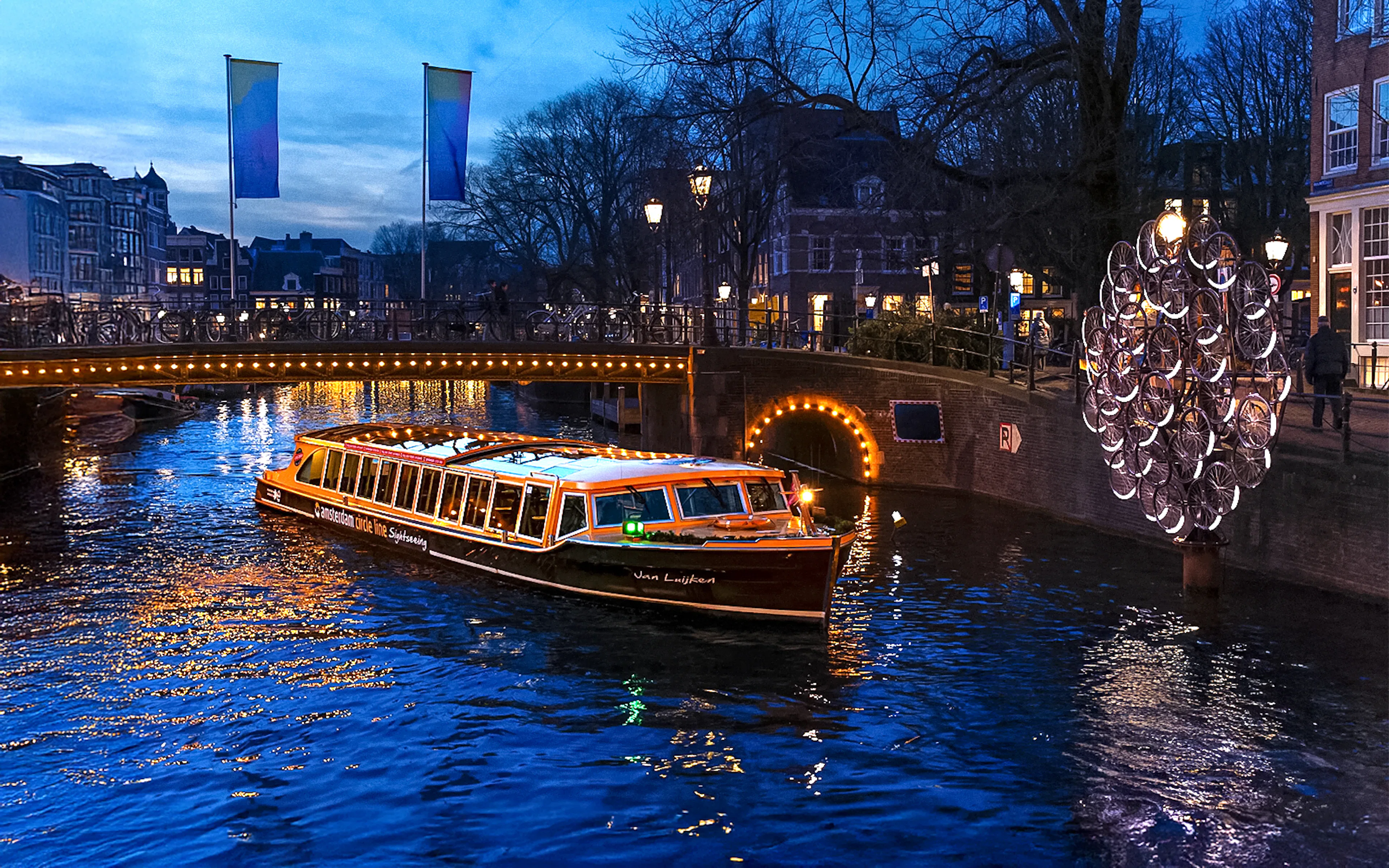 Traditional canal boat cruising during Amsterdam Light Festival.