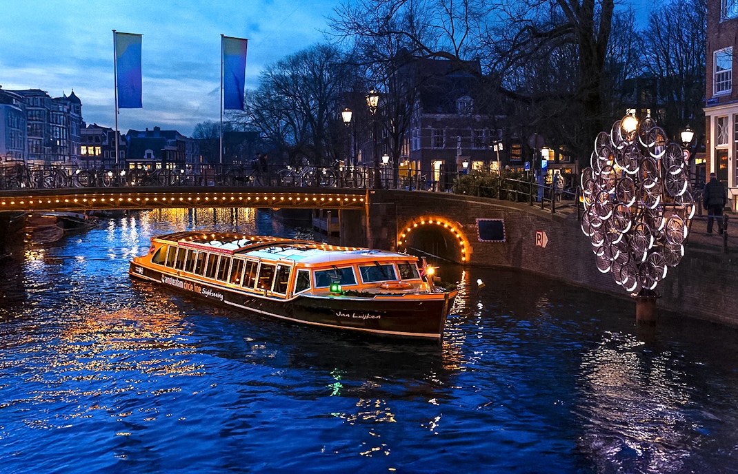 Traditional canal boat cruising during Amsterdam Light Festival.