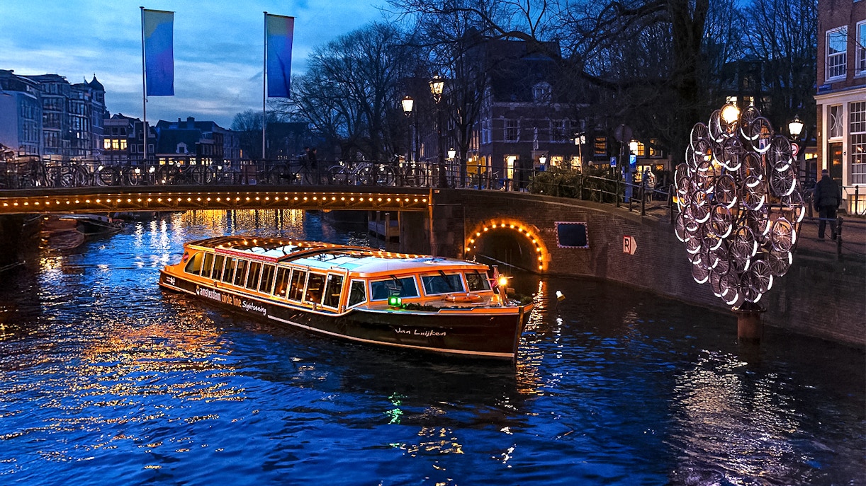 Traditional canal boat cruising during Amsterdam Light Festival.