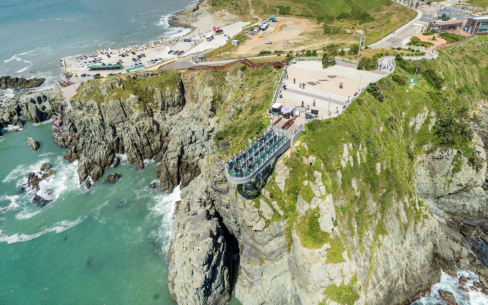 Cliffside view of Blueline Park Sky Capsule in Busan with ocean backdrop.